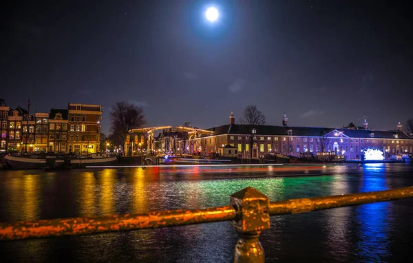 Amsterdam, Hollanda - 12 Ocak 2017: Cruise tekneler acele gece kanallarında. Amsterdam içinde ışık Festivali ışık teçhizatları gece Kanallar üzerinde. 12 Ocak 2017 yılında Amsterdam - Hollanda