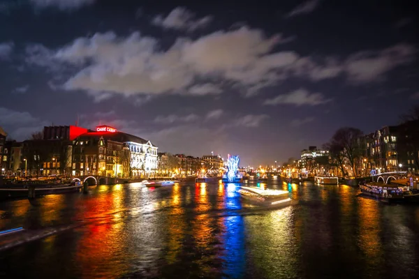 Amsterdam, Nederland - 12 januari 2017: Prachtige nacht stad Amsterdamse grachten met bewegende reizigerskilometers boot. Amsterdam - Nederland, 12 januari 2017. — Stockfoto