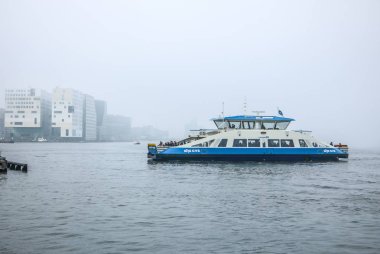 Amsterdam, Hollanda - 02 Ocak 2017: Tekneler sisli günde Merkez İstasyonu pier yakınındaki şehir kanalında. 02 Ocak 2017 yılında Amsterdam - Hollanda.