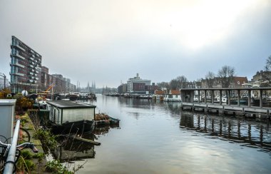 Amsterdam, Hollanda - 28 Aralık 2016: Ünlü binalar ve güneş, Amsterdam şehir merkezinin yer saatini ayarlayın. Genel manzara görünümü. 28 Aralık 2016 - Amsterdam - Hollanda