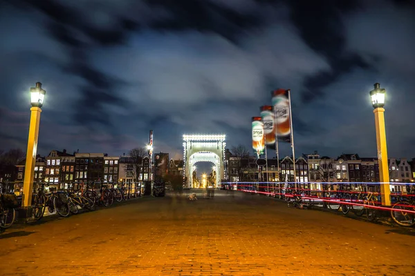 Amsterdam, Nederland - 12 januari 2017: Oude houten Nederlandse brug bij nachttijd tegen rush wolken op 12 januari 2017 in Amsterdam - Nederland. — Stockfoto