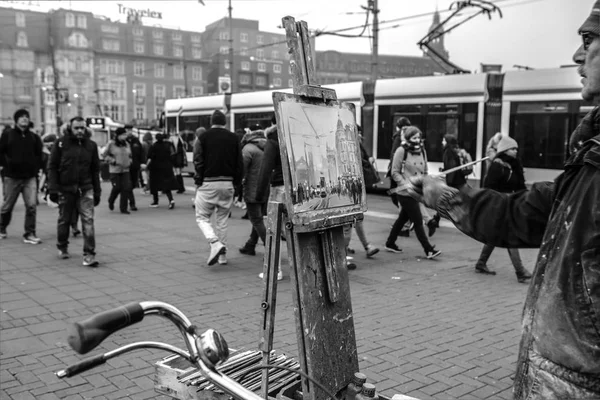 AMSTERDAM, PAÍSES BAJOS - 30 DE DICIEMBRE DE 2016: Artista callejero dibuja el cuadro de pie en la multitud de transeúntes. 30 de diciembre de 2016 - Amsterdam - Países Bajos . — Foto de Stock
