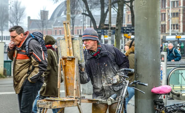 AMSTERDÃO, PAÍSES BAIXOS - DEZEMBRO 30, 2016: Artista de rua desenha o quadro em pé na multidão de transeuntes. 30 de dezembro de 2016 - Amsterdã - Holanda . — Fotografia de Stock