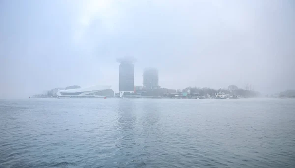 Vista geral do canal da cidade perto do cais da estação central de Amsterdã no dia nebuloso . — Fotografia de Stock