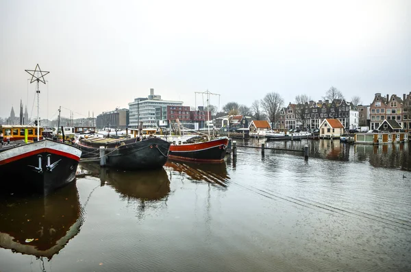 Amsterdam, Nederländerna - 02 januari 2017: Båtar på vattnet i molnigt väder. 02 januari 2017 i Amsterdam - Nederländerna. — Stockfoto