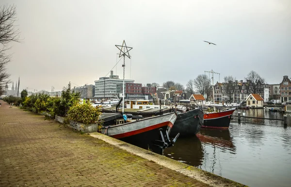 Amsterdam, Nederländerna - 02 januari 2017: Båtar på vattnet i molnigt väder. 02 januari 2017 i Amsterdam - Nederländerna. — Stockfoto