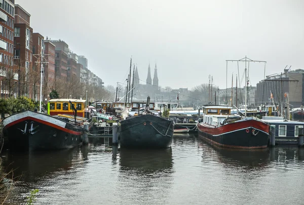 Amsterdam, Nederländerna - 28 December 2016: Berömda byggnader och plats för Amsterdams centrum på sun ställa in tiden. De allmänna liggande vy. 28 december 2016 - Amsterdam - Nederländerna — Stockfoto