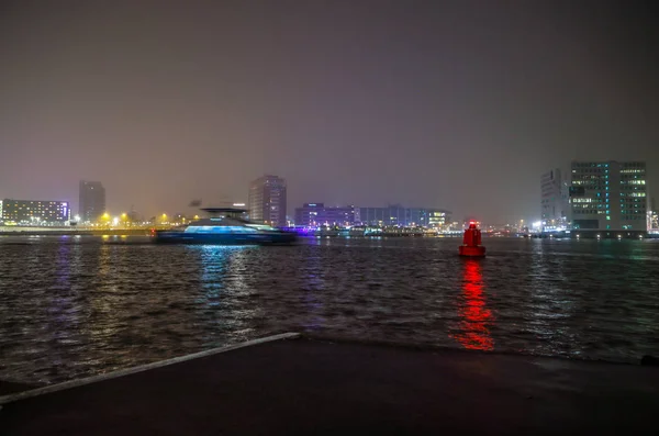 АМСТЕРДАМ, НИДЕРЛАНДЫ - 31 ДЕКАБРЯ 2016: Круизное судно в ночных каналах Амстердама 31 декабря 2016 года в Амстердаме - Нидерланды . — стоковое фото