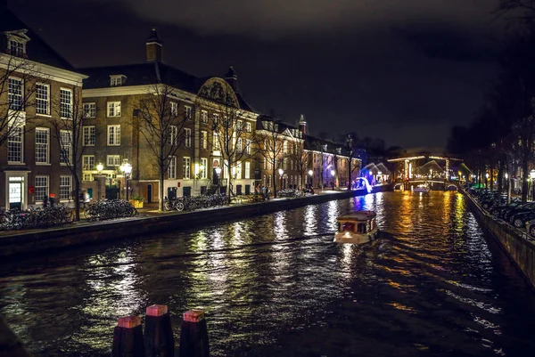 AMSTERDAM, PAYS-BAS - 02 JANVIER 2017 : Bateau de croisière dans les canaux de nuit d'Amsterdam. 02 janvier 2017 à Amsterdam - Pays-Bas . — Photo