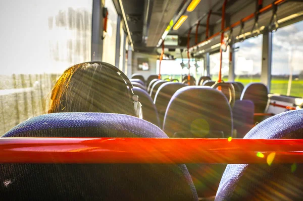 Young woman with long beautiful hairs sit back in empty city bus. — Stock Photo, Image