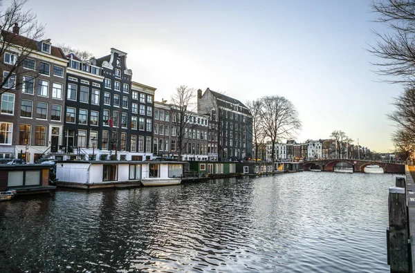 Amsterdam, Nizozemsko - 10 ledna 2017: Slavných historických budov & chanels Amsterdam city na západ slunce. Pohled na obecné krajiny. 10. ledna 2017 - Amsterdam - Nizozemsko — Stock fotografie