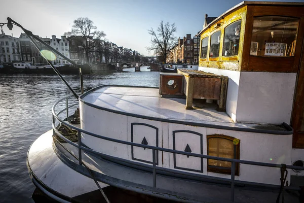 Amsterdam, Nederländerna - 09 januari 2017: Ange båtar på vatten i vacker kvällssol. 09 januari 2017 i Amsterdam - Nederländerna. — Stockfoto