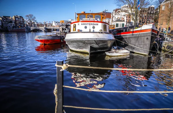 Amsterdam, Nederländerna - 09 januari 2017: Ange båtar på vatten i vacker kvällssol. 09 januari 2017 i Amsterdam - Nederländerna. — Stockfoto