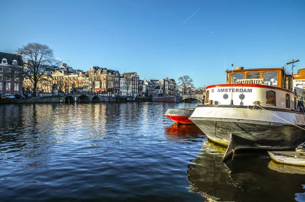 Amsterdam, Nederländerna - 09 januari 2017: Ange båtar på vatten i vacker kvällssol. 09 januari 2017 i Amsterdam - Nederländerna. — Stockfoto