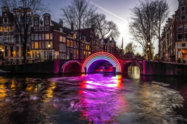Amsterdam, Hollanda - 10 Ocak 2017: Cruise tekneler acele gece kanallarında. Amsterdam içinde ışık Festivali ışık teçhizatları gece Kanallar üzerinde. 10 Ocak 2017 yılında Amsterdam - Hollanda.