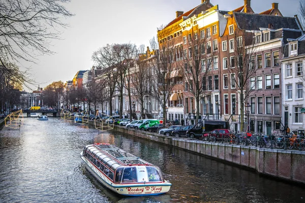 Amsterdam, Nederland - 09 januari 2017: Stel de boten op het water in de prachtige avondzon. 09 januari 2017 in Amsterdam - Nederland. — Stockfoto