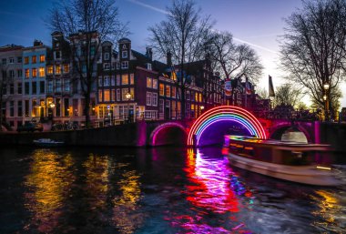 Amsterdam, Hollanda - 10 Ocak 2017: Cruise tekneler acele gece kanallarında. Amsterdam içinde ışık Festivali ışık teçhizatları gece Kanallar üzerinde. 10 Ocak 2017 yılında Amsterdam - Hollanda.