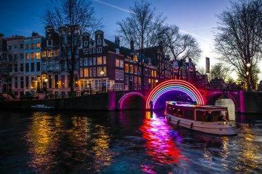 Amsterdam, Hollanda - 10 Ocak 2017: Cruise tekneler acele gece kanallarında. Amsterdam içinde ışık Festivali ışık teçhizatları gece Kanallar üzerinde. 10 Ocak 2017 yılında Amsterdam - Hollanda.