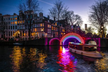 Amsterdam, Hollanda - 10 Ocak 2017: Cruise tekneler acele gece kanallarında. Amsterdam içinde ışık Festivali ışık teçhizatları gece Kanallar üzerinde. 10 Ocak 2017 yılında Amsterdam - Hollanda.