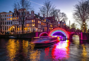 Amsterdam, Hollanda - 10 Ocak 2017: Cruise tekneler acele gece kanallarında. Amsterdam içinde ışık Festivali ışık teçhizatları gece Kanallar üzerinde. 10 Ocak 2017 yılında Amsterdam - Hollanda.