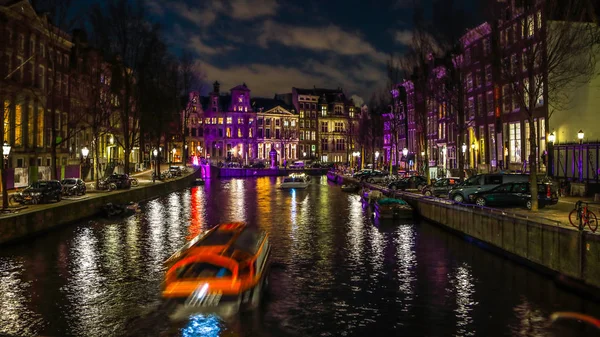 阿姆斯特丹，荷兰-2017 年 1 月 11 日︰ 美丽的夜晚城市运河的阿姆斯特丹与移动客船船。2017 年 1 月 11 日在阿姆斯特丹-荷兰. — 图库照片