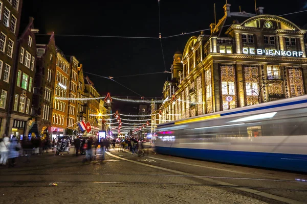 AMSTERDÃO, PAÍSES BAIXOS - JANEIRO 08, 2017: Amsterdam city night streets with different kinds moving transport & silhouettes of passersby. 08 de janeiro de 2017 em Amsterdam - Países Baixos . — Fotografia de Stock