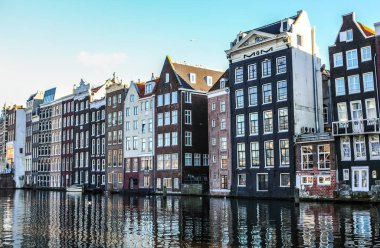 Amsterdam, Hollanda - 17 Aralık 2017: Ünlü binalar ve güneş, Amsterdam şehir merkezinin yer saatini ayarlayın. Genel manzara görünümü. 17 Aralık 2016 - Amsterdam - Hollanda.