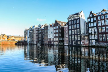 Amsterdam, Hollanda - 17 Aralık 2017: Ünlü binalar ve güneş, Amsterdam şehir merkezinin yer saatini ayarlayın. Genel manzara görünümü. 17 Aralık 2016 - Amsterdam - Hollanda.