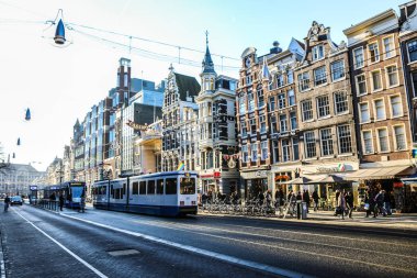 Amsterdam, Hollanda - 17 Aralık 2017: Ünlü binalar ve güneş, Amsterdam şehir merkezinin yer saatini ayarlayın. Genel manzara görünümü. 17 Aralık 2016 - Amsterdam - Hollanda.