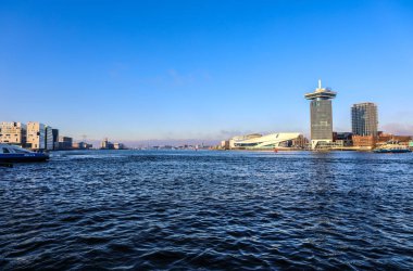 Amsterdam, Hollanda - 17 Aralık 2017: Ünlü binalar ve güneş, Amsterdam şehir merkezinin yer saatini ayarlayın. Genel manzara görünümü. 17 Aralık 2016 - Amsterdam - Hollanda.