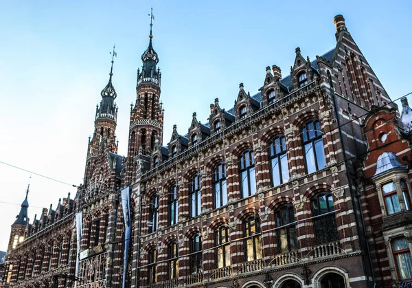 AMSTERDAM, NETHERLANDS - DECEMBER 17, 2017: Famous buildings and place of Amsterdam city centre at sun set time. General landscape view. December 17, 2016 - Amsterdam - Netherlands. — Stock Photo, Image