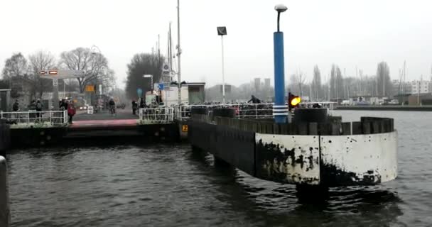 AMSTERDAM, PAÍSES BAJOS - 02 DE ENERO DE 2017: Barcos en el canal de la ciudad cerca del muelle de la estación central en el día de niebla. Vídeo 4K. Enero 02, 2017 en Amsterdam - Holanda . — Vídeo de stock