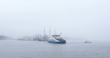 Amsterdam, Hollanda - 02 Ocak 2017: Tekneler sisli günde Merkez İstasyonu pier yakınındaki şehir kanalında. 4k Video. 02 Ocak 2017 yılında Amsterdam - Hollanda.