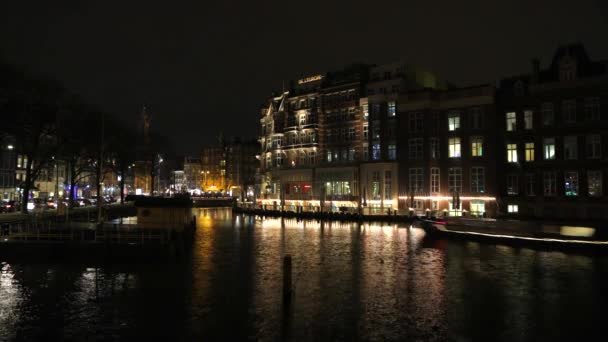 AMSTERDAM, PAYS-BAS - 06 JANVIER 2017 : Les bateaux de croisière se précipitent dans les canaux nocturnes de la ville d'Amsterdam. Temps écoulé. 06 janvier 2017 à Amsterdam - Pays-Bas . — Video