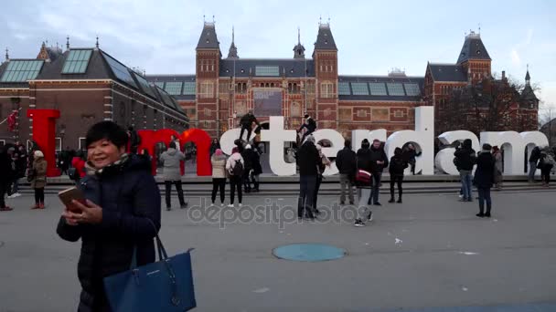 Amsterdam, Nederland - 05 januari 2017: Rush hour in Amsterdam buiten Rijksmuseum. Menigte van toeristen doen een foto in de buurt van teken 'I Amsterdam'. Time-lapse. 05 januari 2017 - Amsterdam - Nederland. — Stockvideo