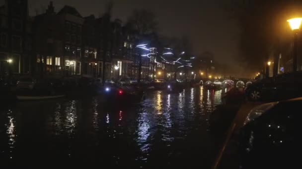 AMSTERDAM, PAYS-BAS - 06 JANVIER 2017 : Les bateaux de croisière se précipitent dans les canaux nocturnes de la ville d'Amsterdam. Temps écoulé. 06 janvier 2017 à Amsterdam - Pays-Bas . — Video