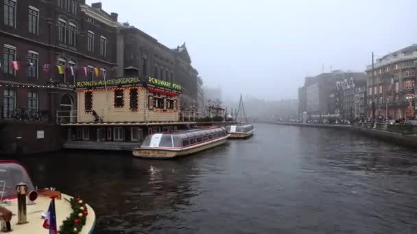 Amsterdam, Nederland - 02 januari 2017: Cruise boot in de grachten van Amsterdam bij mistig avond. Time-lapse. op 02 januari 2017 in Amsterdam - Nederland. — Stockvideo