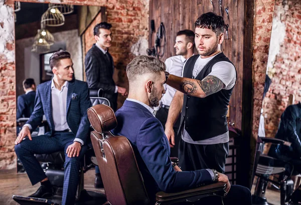 Groep van jonge elegante positief mens in interieur van barbershop poseren. — Stockfoto