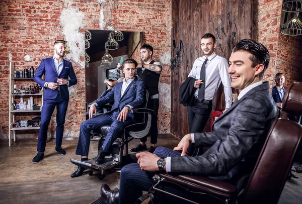 Grupo de jovens elegantes homens positivos posar no interior da barbearia . — Fotografia de Stock