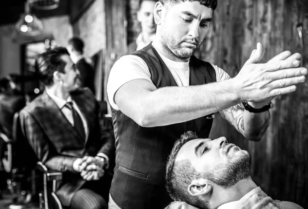 Master hace corrección de barbas en el salón de peluquería. Foto en blanco y negro . — Foto de Stock