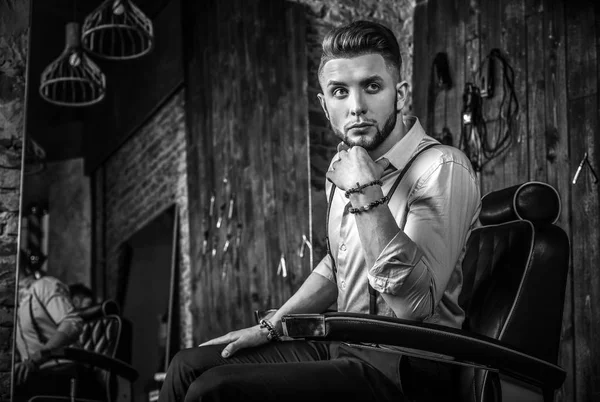 Elegant ung man i barbershop. Svart-vitt foto. — Stockfoto