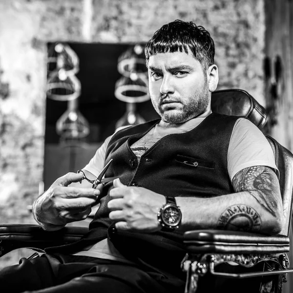 Um jovem elegante na barbearia. Foto preto-branco . — Fotografia de Stock