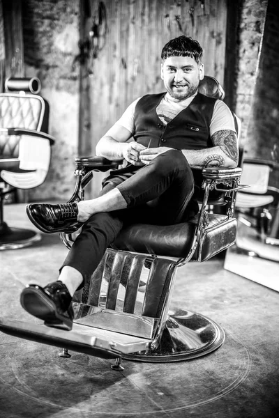 Um jovem elegante na barbearia. Foto preto-branco . — Fotografia de Stock