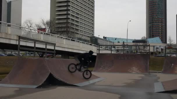 Jovem pulando com sua bicicleta BMX no parque de skate. Ultra HD Filmagem . — Vídeo de Stock