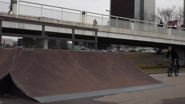 Молодой человек прыгает на велосипеде BMX в скейт-парке. Slow Motion Footage . — стоковое видео