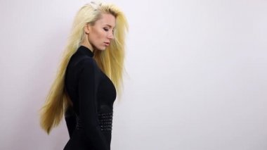Siyah elbiseli güzel seksi sarışın kadın poz studio arka planı. Ağır çekim görüntüleri.