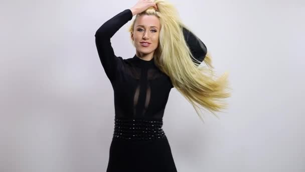 검은 드레스에 아름 다운 섹시 한 금발 여자 포즈 스튜디오 배경. 슬로우 모션 장면. — 비디오