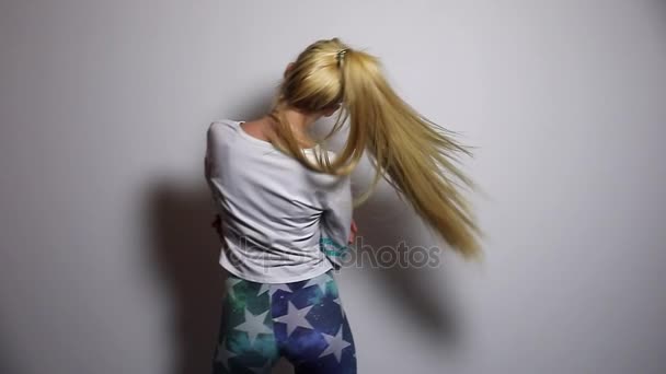 Beautiful sexy blonde sporty woman dance and shake hairs against studio background. Slow Motion Footage. — Stock Video