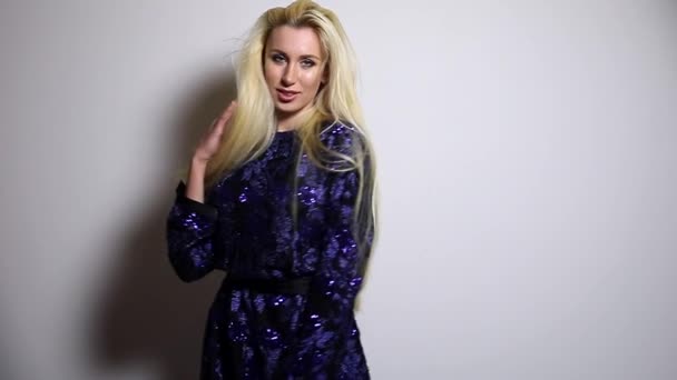 Hermosa mujer rubia sexy en azul oscuro pose vestido largo contra fondo de estudio. Grabación en cámara lenta . — Vídeo de stock