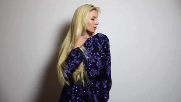 Beautiful sexy blonde woman in dark blue long dress pose against studio background. Slow Motion Footage. — Stock Video